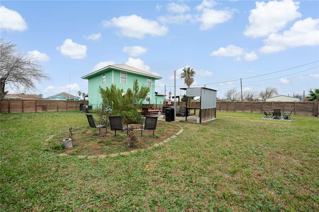 view of yard with an outdoor fire pit and a fenced backyard