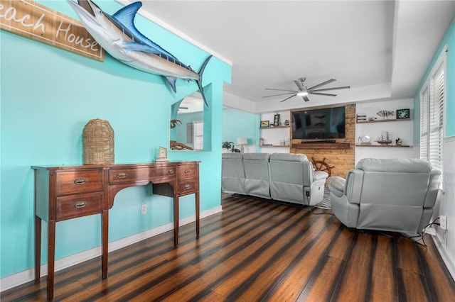 interior space featuring ceiling fan, baseboards, and wood finished floors