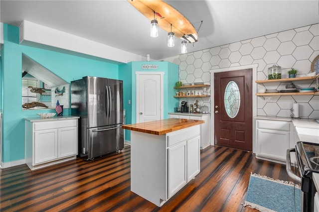 kitchen with butcher block countertops, white cabinets, freestanding refrigerator, electric range oven, and open shelves