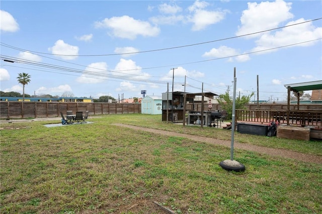 view of yard with an outbuilding, a storage unit, and fence