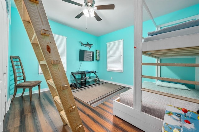 interior space featuring wood finished floors, a ceiling fan, and baseboards