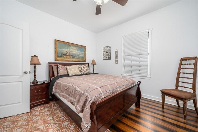 bedroom featuring ceiling fan, wood finished floors, and baseboards