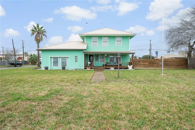 view of front of house featuring metal roof, a porch, a front yard, and fence