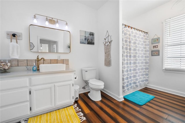 bathroom featuring baseboards, vanity, toilet, and wood finished floors