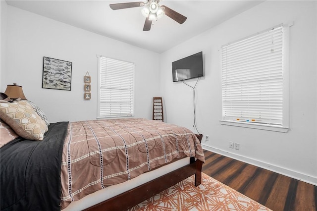 bedroom featuring a ceiling fan, baseboards, and dark wood-type flooring