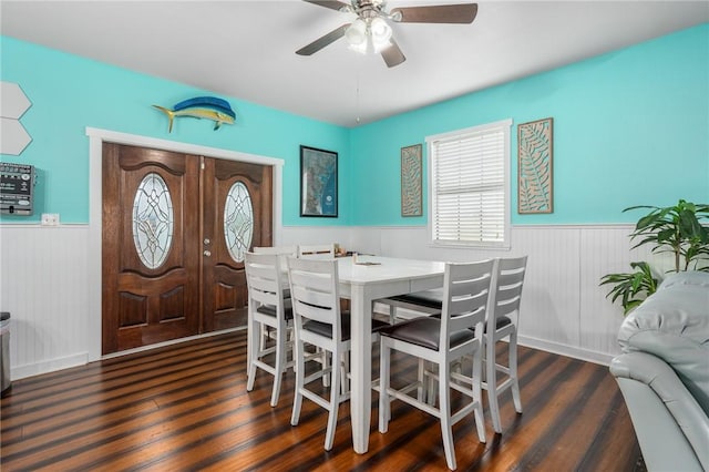 dining area with ceiling fan, wood finished floors, and wainscoting