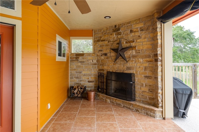 unfurnished living room with tile patterned flooring and an outdoor stone fireplace