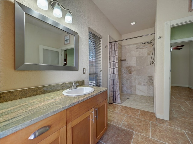 bathroom featuring a shower with curtain, ceiling fan, and vanity