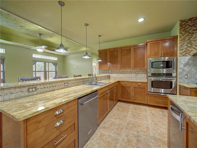 kitchen featuring backsplash, appliances with stainless steel finishes, pendant lighting, sink, and ceiling fan