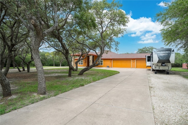 single story home with a garage and a front lawn