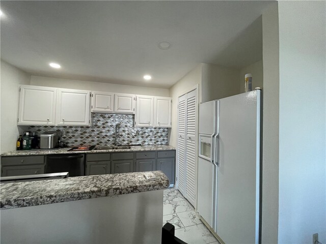 kitchen with sink, tasteful backsplash, white fridge with ice dispenser, white cabinets, and dishwasher