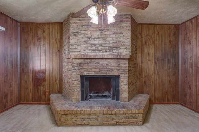5802 Riley Dr, Corpus Christi, TX 78412 - carpeted living room with wooden walls, a ceiling fan, a textured ceiling, and a brick fireplace