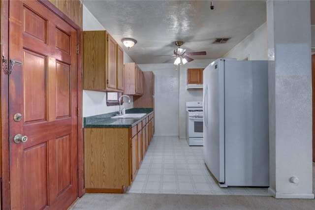 5802 Riley Dr, Corpus Christi, TX 78412 - kitchen featuring white appliances, ceiling fan, light flooring, dark countertops, and under cabinet range hood