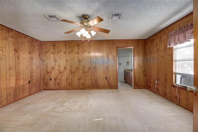 5802 Riley Dr, Corpus Christi, TX 78412 - empty room featuring cooling unit, a ceiling fan, wooden walls, light carpet, and a textured ceiling