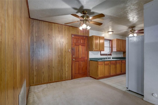 5802 Riley Dr, Corpus Christi, TX 78412 - kitchen featuring freestanding refrigerator, a ceiling fan, wood walls, a textured ceiling, and dark countertops