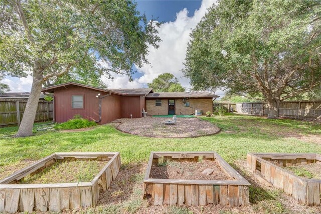 5802 Riley Dr, Corpus Christi, TX 78412 - back of house featuring a vegetable garden and a fenced backyard
