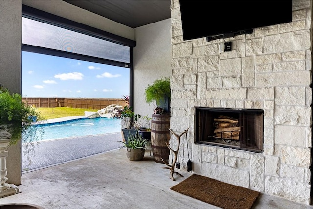 view of patio featuring a fenced in pool and an outdoor stone fireplace