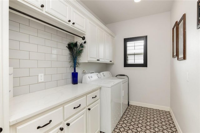 washroom featuring washing machine and clothes dryer and cabinets