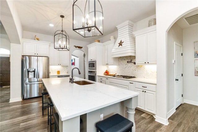 kitchen featuring white cabinetry, an island with sink, pendant lighting, and appliances with stainless steel finishes