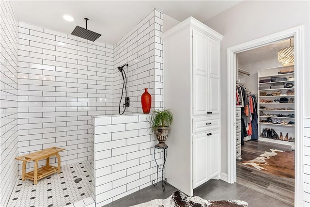 bathroom with a tile shower and tile patterned flooring