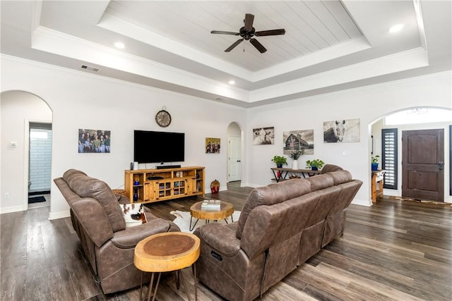 living room featuring a tray ceiling, ceiling fan, and ornamental molding