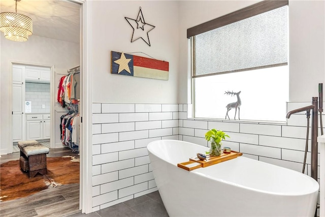 bathroom featuring a washtub, tile walls, and tile patterned flooring