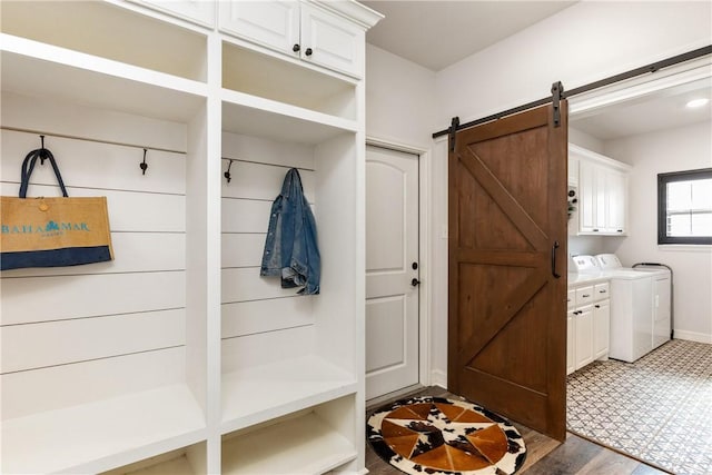 mudroom with dark hardwood / wood-style flooring, a barn door, and separate washer and dryer