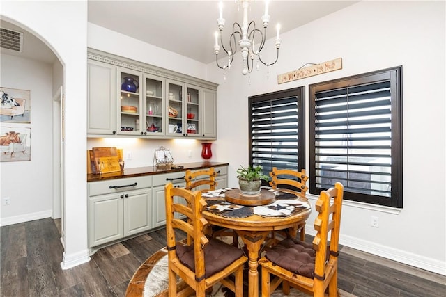 dining area with dark hardwood / wood-style flooring and a chandelier