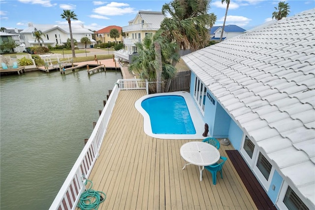 view of swimming pool with a dock and a water view