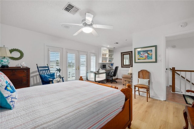 bedroom featuring ceiling fan, light hardwood / wood-style floors, and french doors