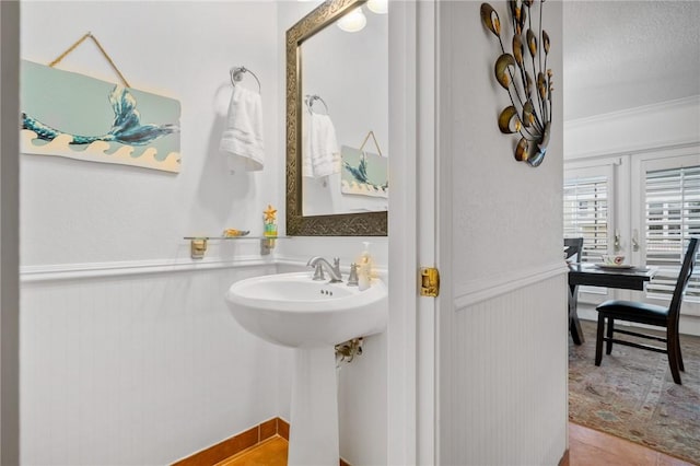 bathroom with sink, crown molding, and tile patterned flooring