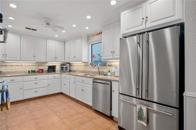 kitchen featuring ceiling fan, tasteful backsplash, sink, white cabinetry, and appliances with stainless steel finishes