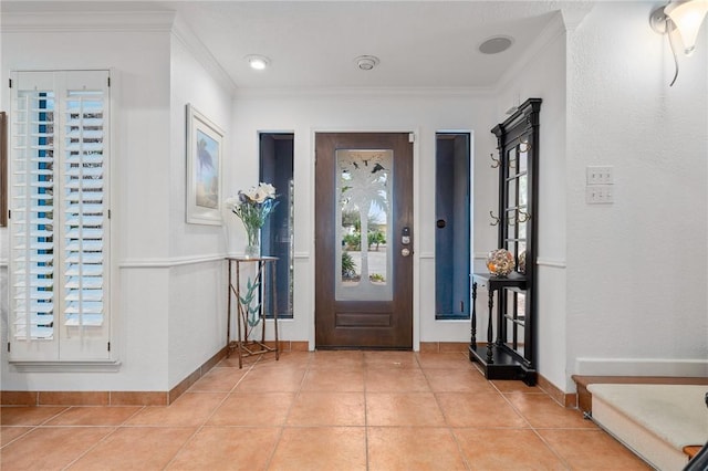 tiled foyer entrance featuring a healthy amount of sunlight and crown molding