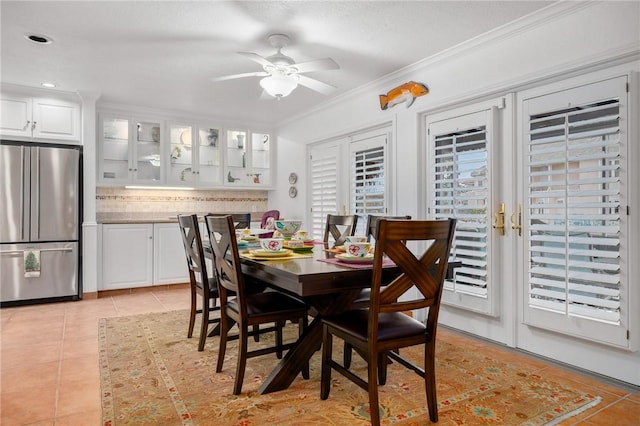 dining space with ceiling fan, light tile patterned flooring, and crown molding