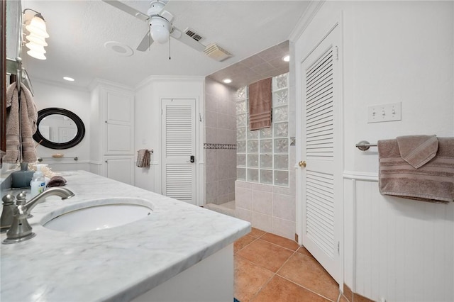 bathroom featuring ceiling fan, vanity, tile patterned flooring, tiled shower, and ornamental molding