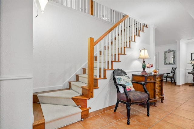 stairway featuring crown molding and tile patterned flooring