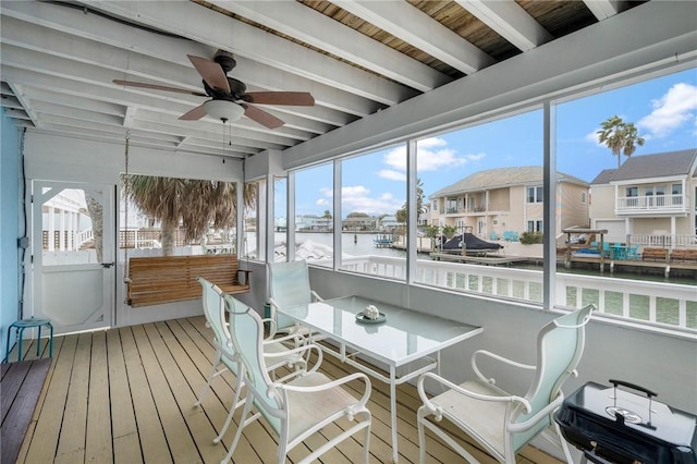 sunroom / solarium with ceiling fan, a water view, and beamed ceiling