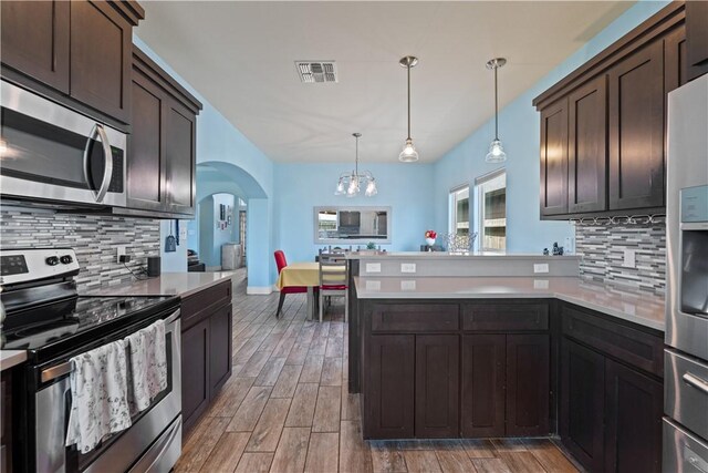 7338 Allman Dr, Corpus Christi, TX 78414 - kitchen with appliances with stainless steel finishes, a peninsula, arched walkways, a chandelier, and light countertops