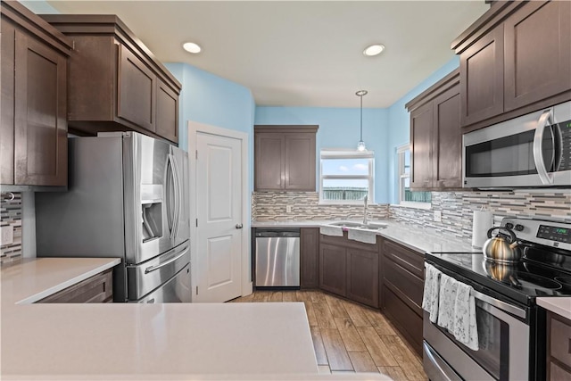 7338 Allman Dr, Corpus Christi, TX 78414 - kitchen with appliances with stainless steel finishes, tasteful backsplash, light countertops, light wood-style flooring, and recessed lighting