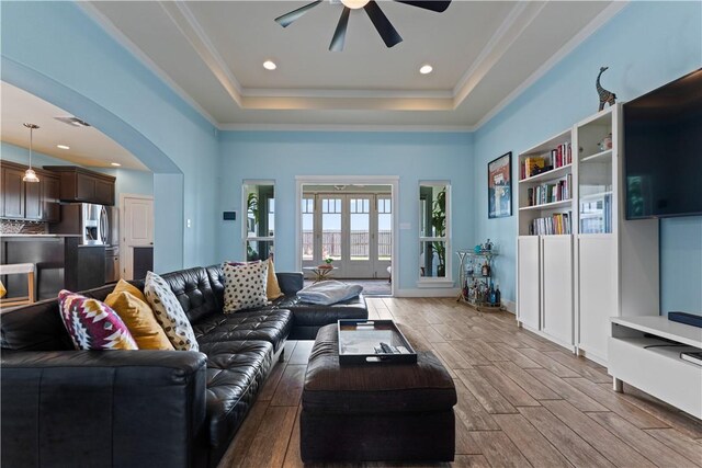 7338 Allman Dr, Corpus Christi, TX 78414 - living room with ceiling fan, wood finished floors, arched walkways, a tray ceiling, and ornamental molding
