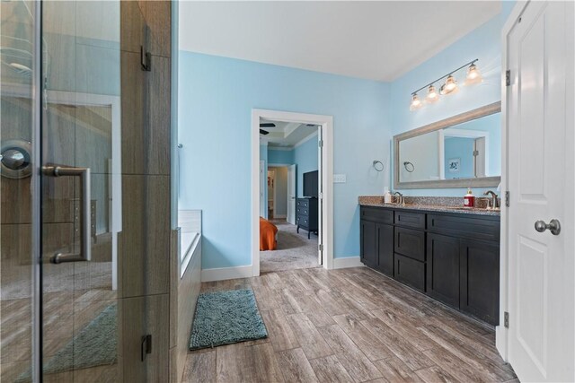 7338 Allman Dr, Corpus Christi, TX 78414 - full bathroom featuring double vanity, wood finished floors, a stall shower, and a bath