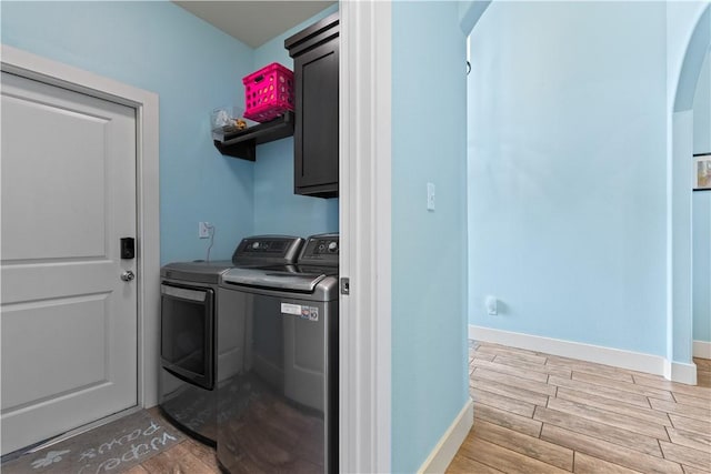 7338 Allman Dr, Corpus Christi, TX 78414 - laundry room featuring washer and dryer, cabinet space, arched walkways, and light wood-style floors