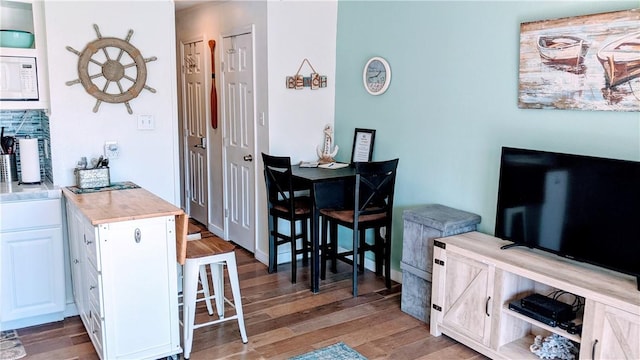 3938 Surfside Blvd Unit 2236, Corpus Christi, TX 78402 - kitchen featuring white microwave, light wood finished floors, white cabinets, and light countertops