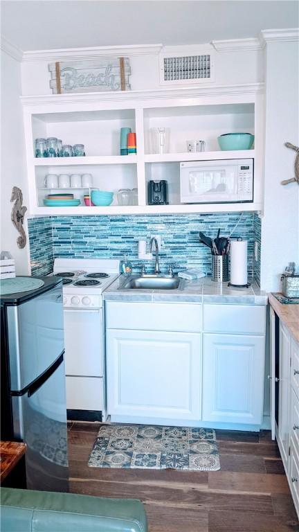 3938 Surfside Blvd Unit 2236, Corpus Christi, TX 78402 - bar featuring a sink, white appliances, dark wood-style floors, ornamental molding, and backsplash