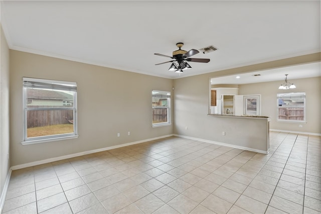 empty room featuring a healthy amount of sunlight, crown molding, and light tile patterned floors