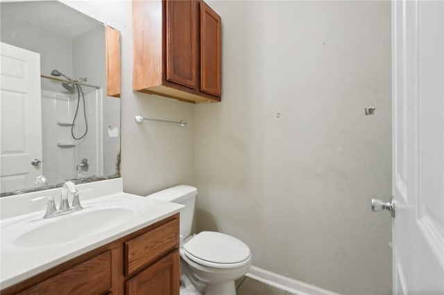 bathroom featuring toilet, vanity, and walk in shower