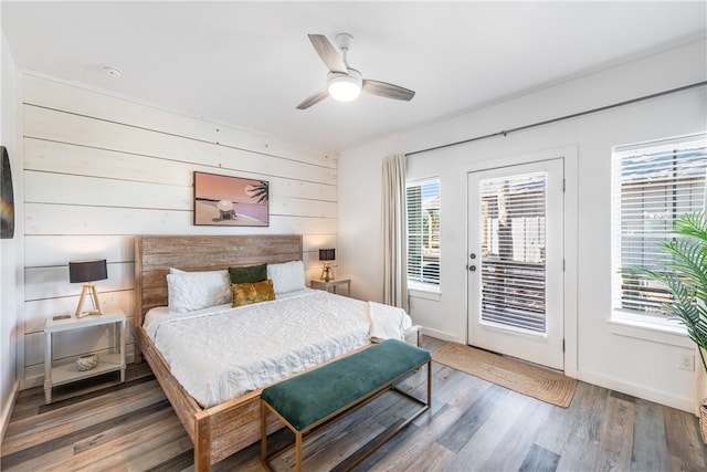 bedroom with ceiling fan, wood-type flooring, access to outside, and multiple windows