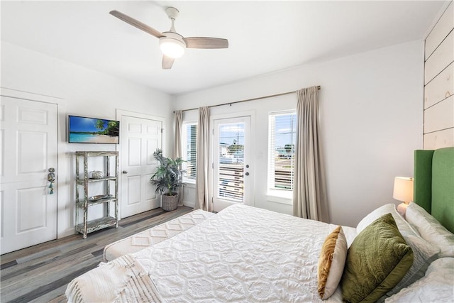 bedroom with access to exterior, ceiling fan, and dark hardwood / wood-style floors