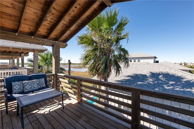 wooden terrace featuring outdoor lounge area and a water view