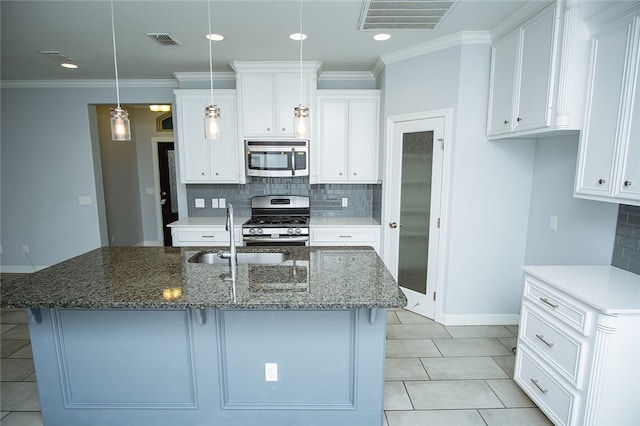 kitchen with white cabinets, stainless steel appliances, hanging light fixtures, and dark stone counters